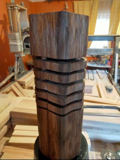 Dreidimensionaler Holzblock mit vertikalen Rillen und abgeschrägter Oberseite.